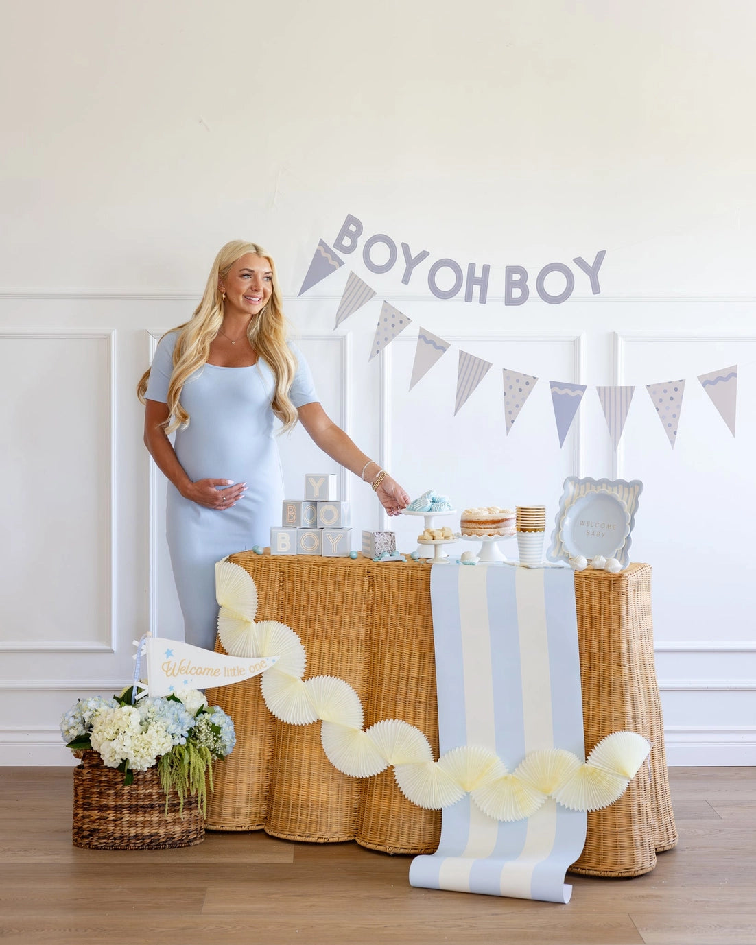 Woman standing next to a decorated table with 'BOY OH BOY' banner