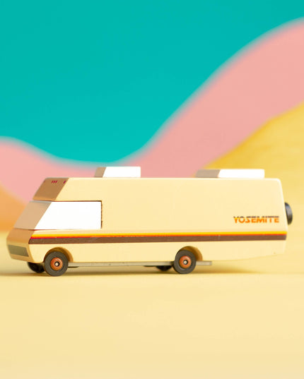 Vintage-style van on a desert landscape with colorful hills in the background