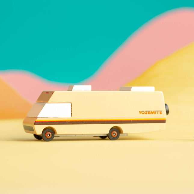 Vintage-style van on a desert landscape with colorful hills in the background