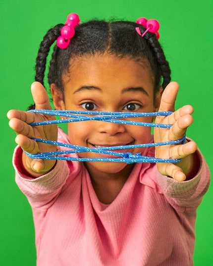 Child holding blue slime in front of a green background