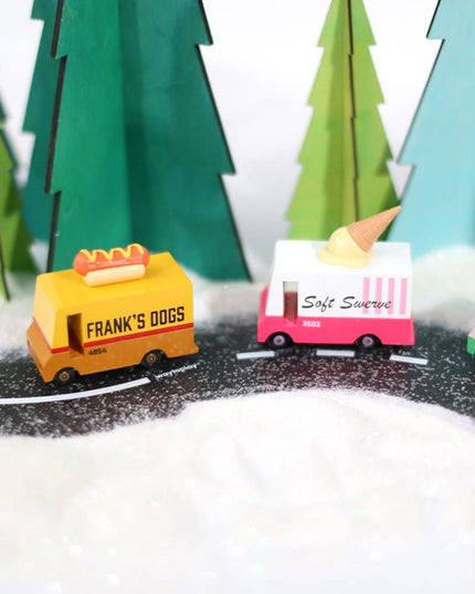 Toy trucks on a miniature road with trees in the background
