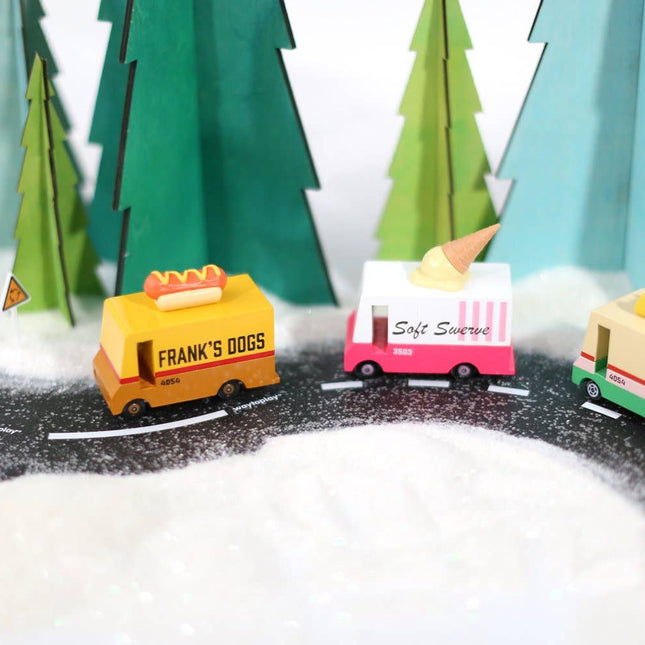 Toy trucks on a miniature road with trees in the background