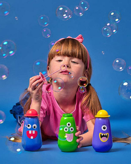 Child blowing bubbles with colorful bubble wands against a blue background