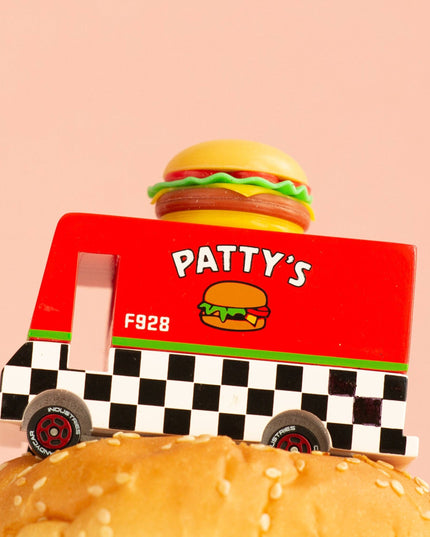 Toy truck labeled 'Patty's' with a hamburger on top of a bun against a pink background
