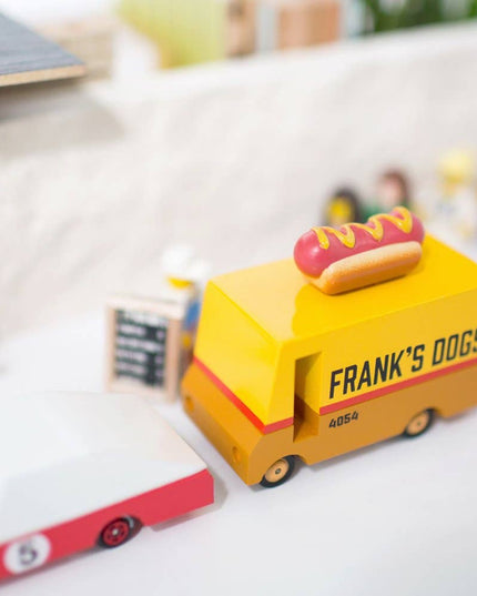 Toy hot dog cart with 'Frank's Dogs' branding on a white surface.