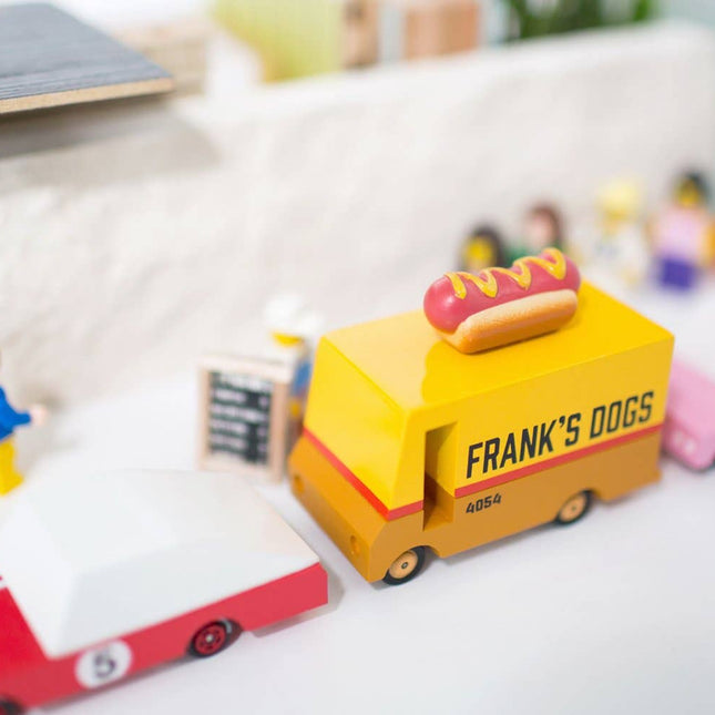 Toy hot dog cart with 'Frank's Dogs' branding on a white surface.