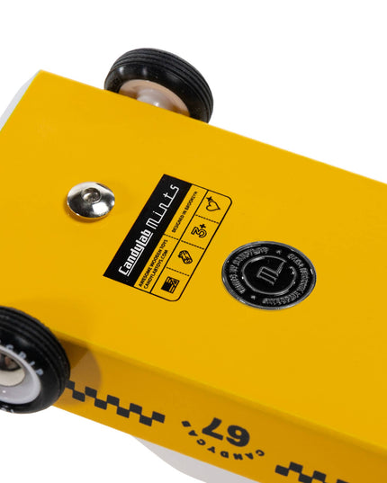 Yellow metal block with wheels and a label on a white background