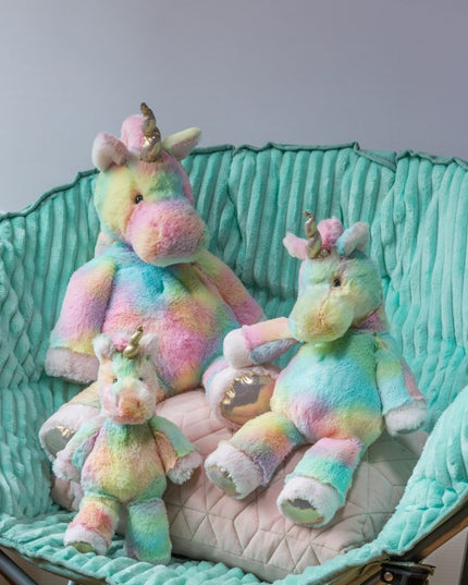 Three colorful unicorn plush toys sitting on a teal chair with a white cushion.