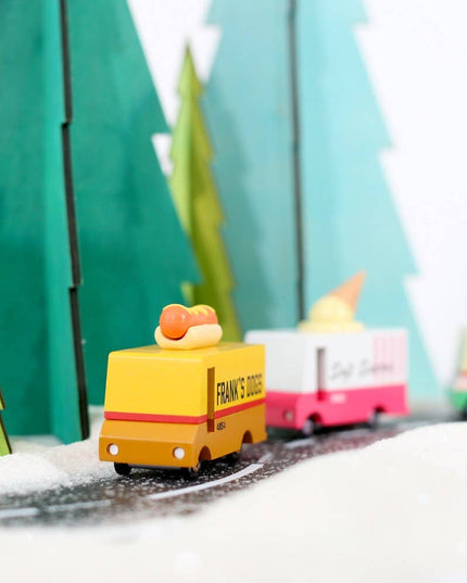 Toy trucks on a track with green trees in the background