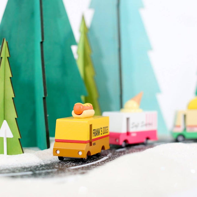 Toy trucks on a track with green trees in the background