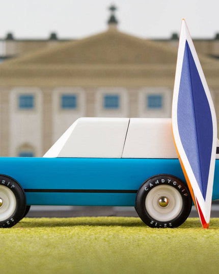 Model car with a sail in front of a building