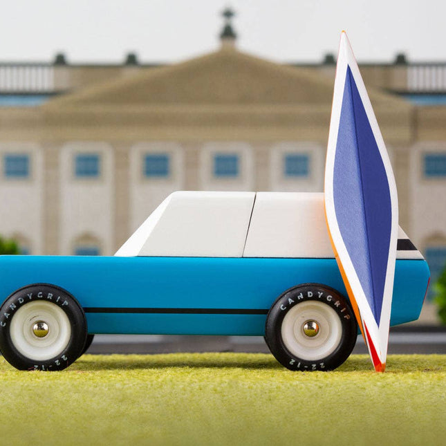 Model car with a sail in front of a building