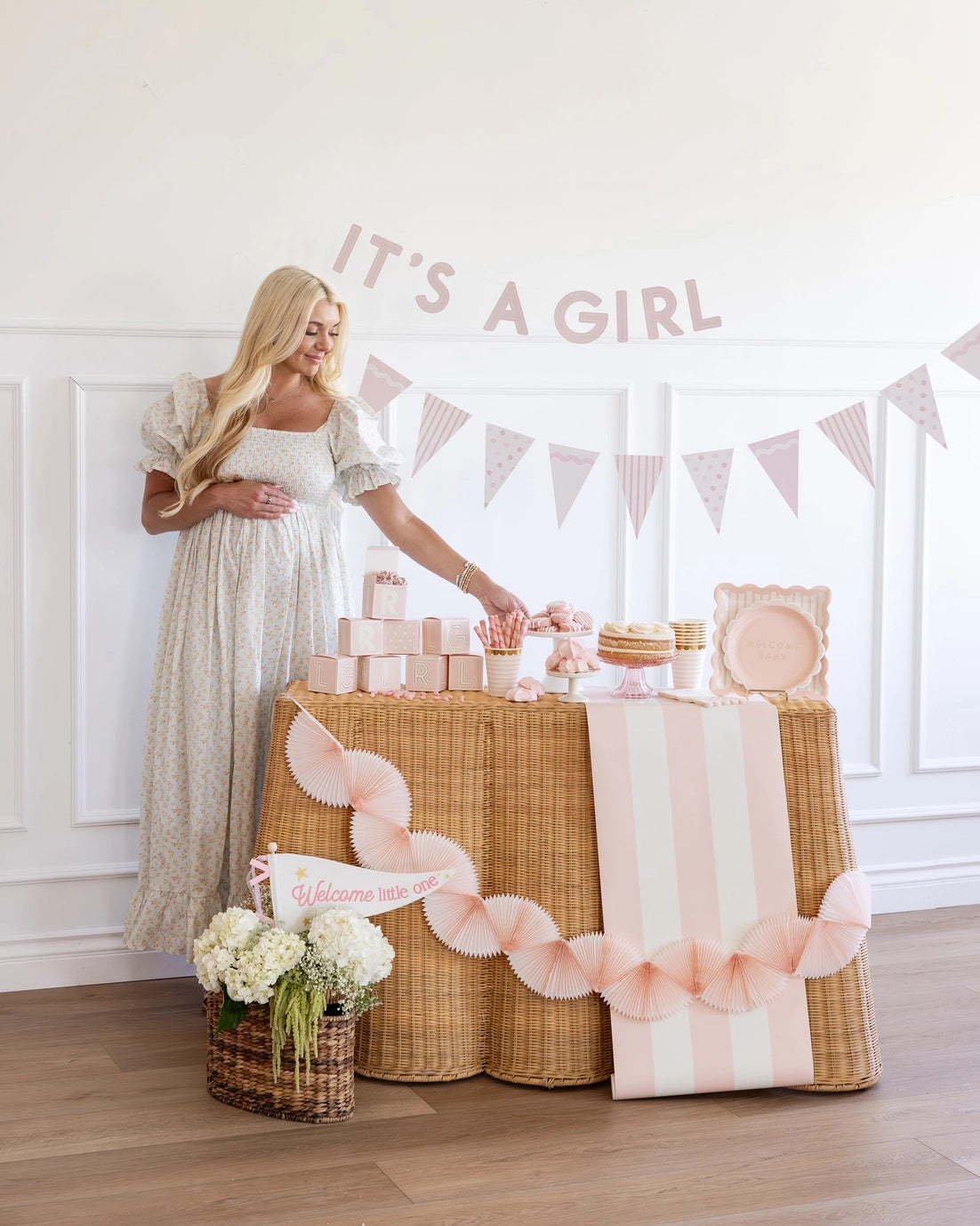 Woman standing next to a decorated table with 'It's a Girl' banner