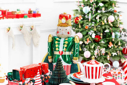 Decorative nutcracker with a Christmas tree and table setting in the background