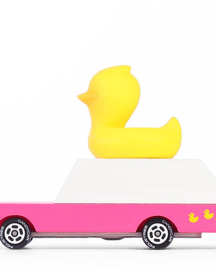 Yellow rubber duck on a pink car with a white background