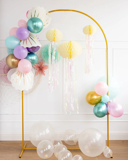 Decorative arch with colorful balloons and paper lanterns on a wooden floor.
