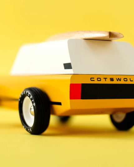 Yellow toy car with white top and 'Cotswold' branding on a yellow background