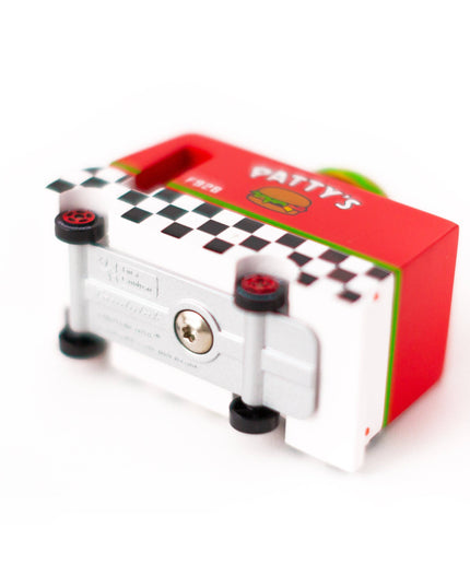 Small mechanical device with a red box featuring 'Patty's' branding on a white background
