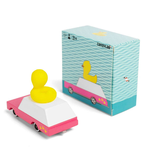 Yellow duck on a pink car with a blue box on a white background