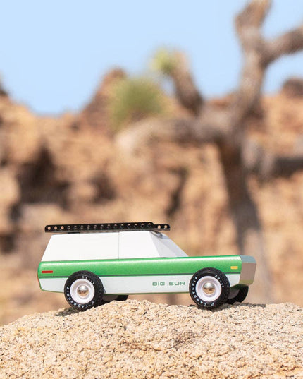 Toy truck on a sand dune with desert landscape in the background