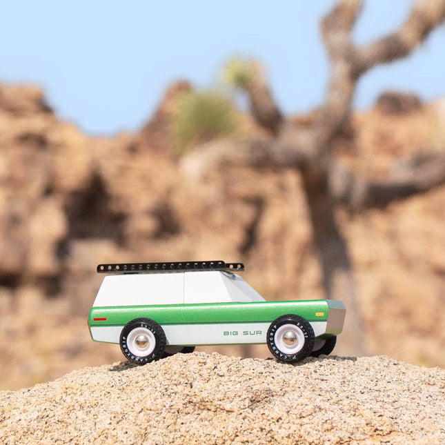 Toy truck on a sand dune with desert landscape in the background