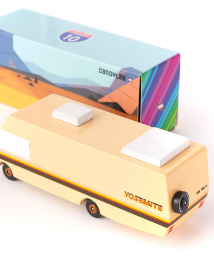 Small yellow vehicle model with a colorful box in the background