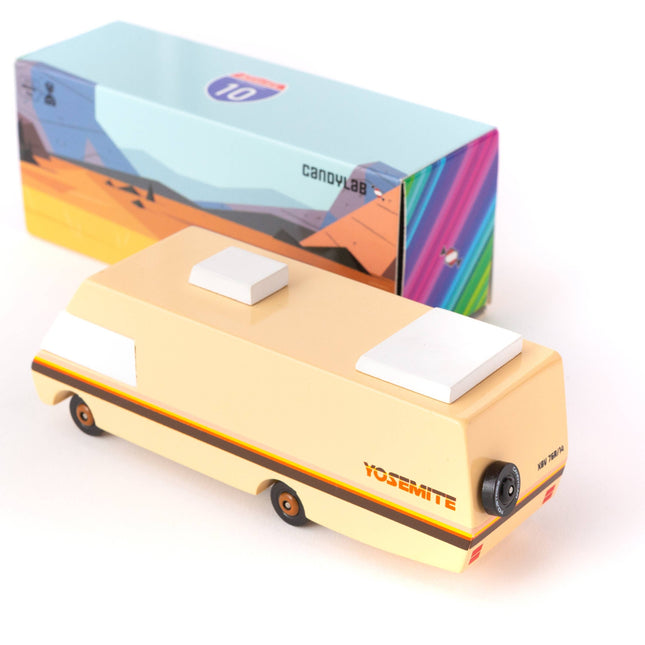 Small yellow vehicle model with a colorful box in the background