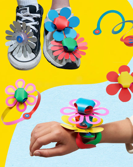 Colorful flower-shaped accessories on shoes and a wrist against a yellow and blue background