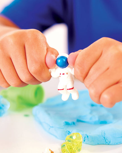 Child playing with an astronaut figure on a blue slime surface