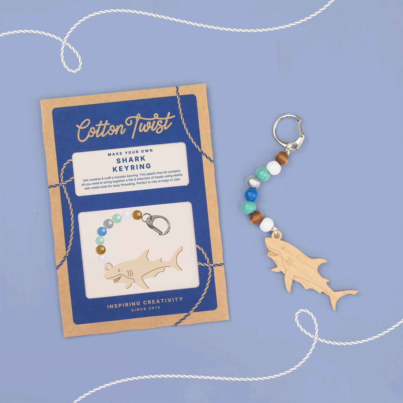 Cotton Twist shark keyring kit with wooden shark shape and colorful beads on a blue background