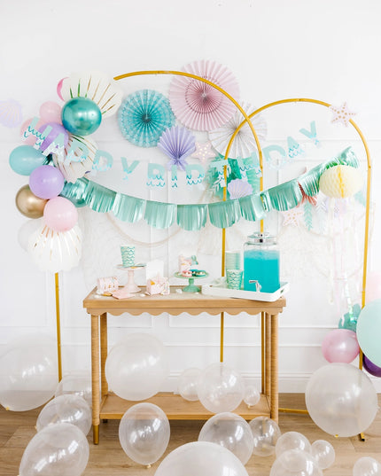 Decorated birthday party setup with balloons and a table.