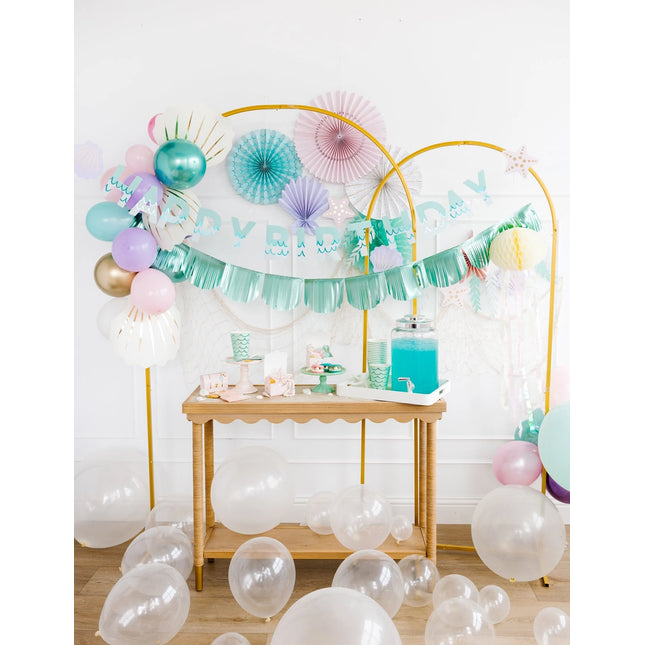 Decorated birthday party setup with balloons and a table.