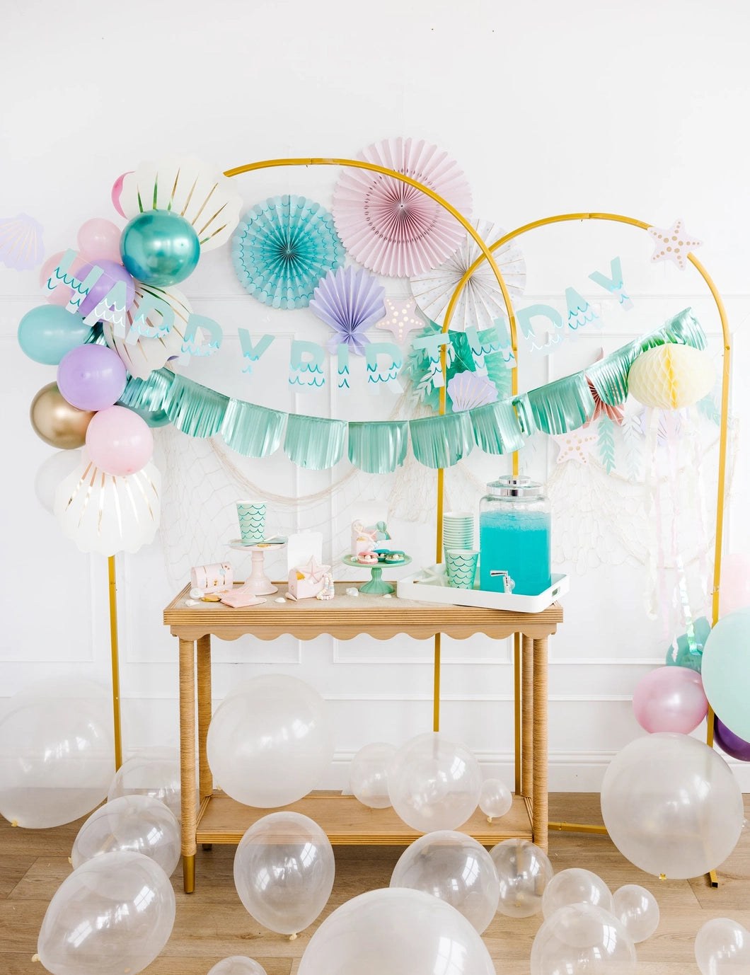 Decorated birthday party setup with balloons and a table.