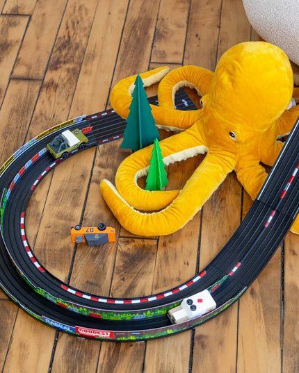 Toy track set with a yellow octopus toy on a wooden floor