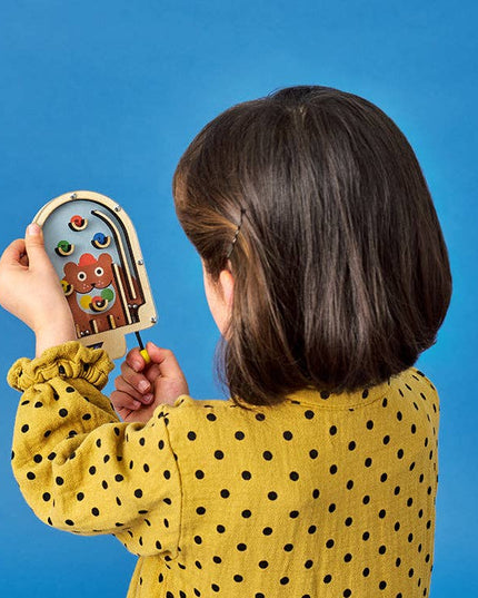 Child holding a wooden toy with colorful characters against a blue background