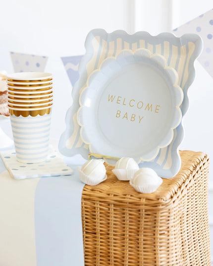 Decorative display with baby shower plate and 'Welcome Baby' text on a table with party supplies.