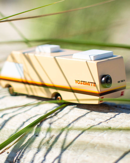 Toy camper on a rock with grass in the background
