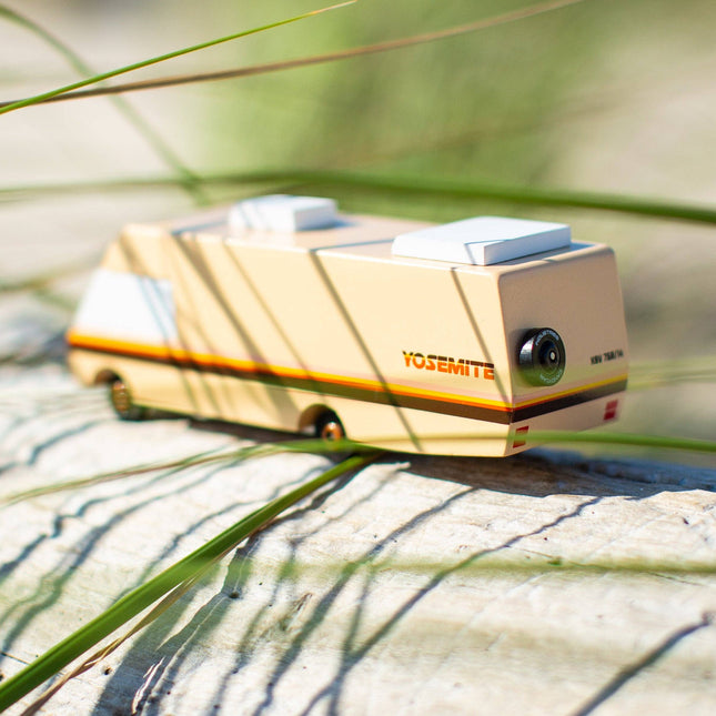 Toy camper on a rock with grass in the background