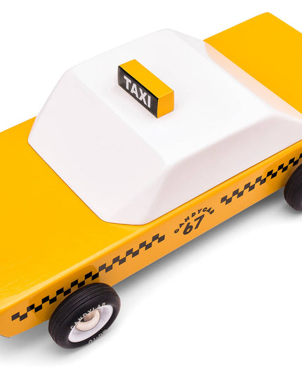 Toy taxi model with yellow body and white roof on a white background
