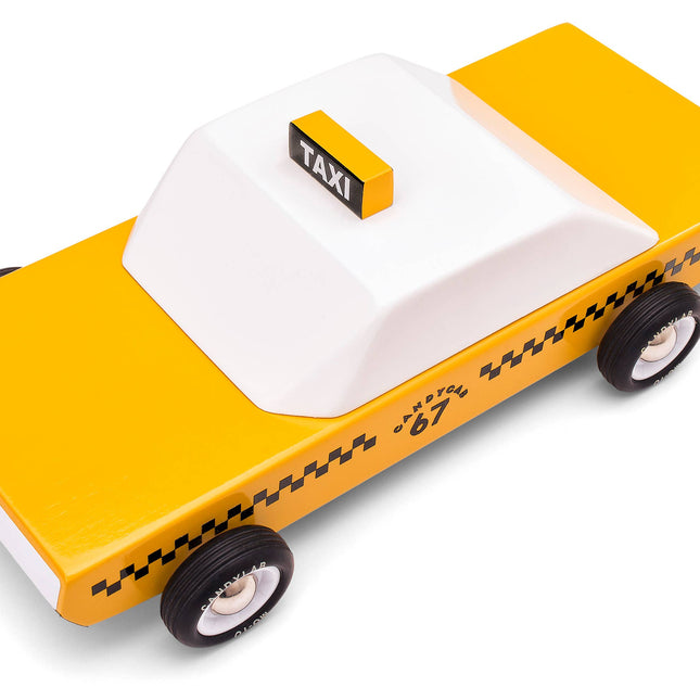 Toy taxi model with yellow body and white roof on a white background