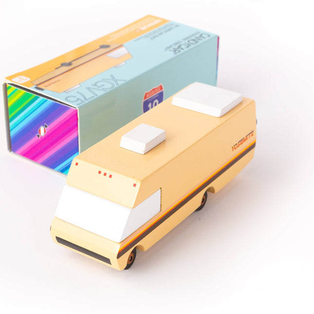 Toy van with a beige body and black wheels on a white background