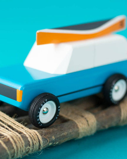 Toy car on a wooden ramp with a blue background