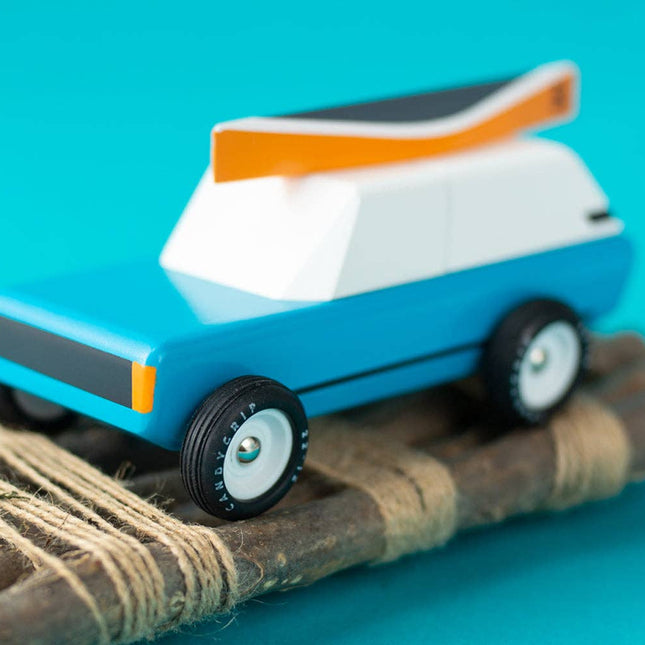 Toy car on a wooden ramp with a blue background