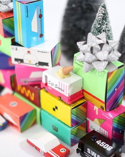 Colorful gift boxes with Christmas trees and decorative items on a white background